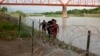 Tres cubanos llegan a suelo estadounidense tras cruzar el Río bravo en Eagle Pass, Texas, el 22 de mayo de 2022. Al otro lado de la frontera muchos cubanos temen que un cambio migratorio les impida llegar a Estados Unidos. (AP Foto/Dario Lopez-Mills)
