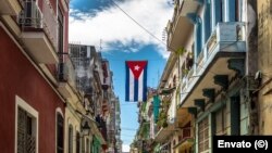 La bandera cubana cuelga en medio de una calle en La Habana Vieja, Cuba.