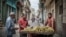Cubanos compran plátanos a un vendedor ambulante en La Habana, en diciembre de 2018. 