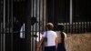 Dos personas esperan su turno en el exterior de la embajada de Estados Unidos el día después de la reapertura de los servicios consulares, en La Habana. (Ramón Espinosa/AP)