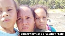 Elianni Villavicencio, esposa del preso político Alexander Verdecia, con las hijas de ambos, espera la asistencia de las autoridades en la azotea de un edificio de su poblado.