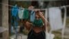 Una mujer del Mariel tiende nasobucos de tela el jueves luego de lavarlos (Foto: Yamil Lage/AFP).
